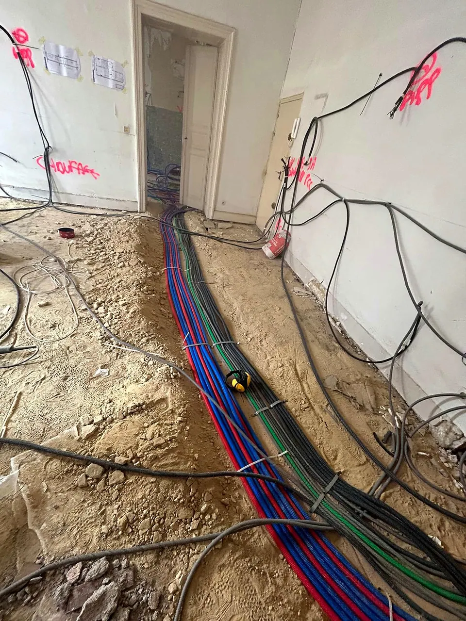 Gaines électriques posées en tranchée pendant une rénovation